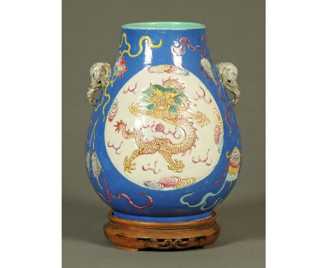 A Famille Rose vase, late Quing, archaistic Hu form, with baluster body with elephant mask handles and each side with a circu