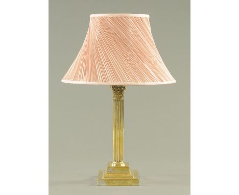 A brass table lamp, early 20th century, with Corinthian capital on a fluted column in turn above a square stepped base and wi