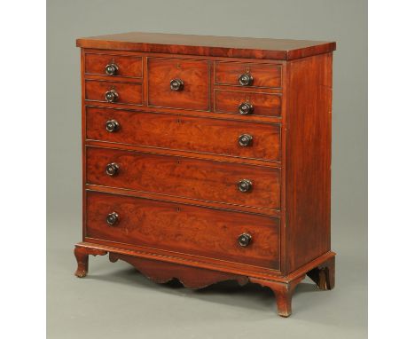 A Victorian mahogany chest of drawers, various short and three long drawers with wooden knob handles, with shaped apron benea