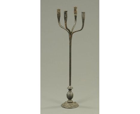 A 19th century iron four branch rush light or candle holder, the base moulded in relief with rampant lions.  Height 81 cm. 