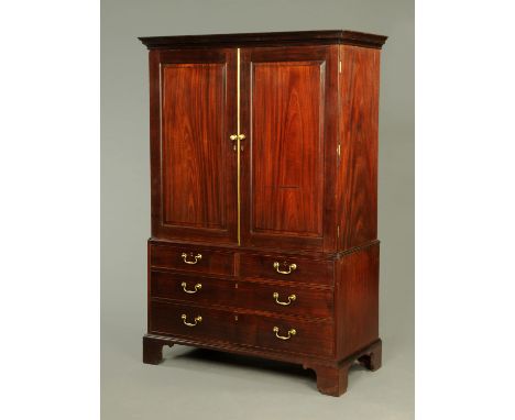 A George III mahogany gentleman's press, with moulded cornice above a pair of panelled doors with brass knob handles enclosin