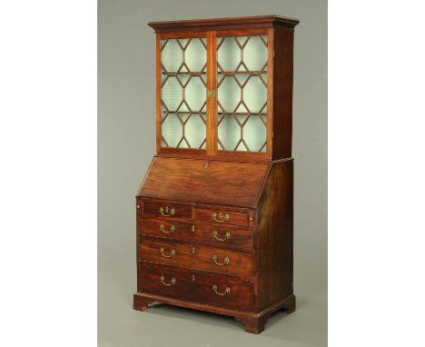 A George III mahogany bureau bookcase, with moulded cornice above a pair of glazed doors enclosing shelves, the base with slo