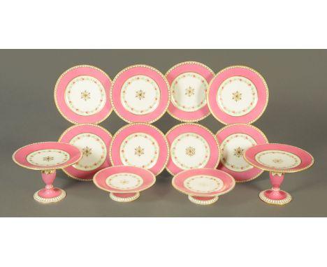 An English porcelain twelve piece part dessert service, circa 1900, decorated with a band of roses against a salmon pink and 