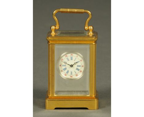 A miniature brass carriage clock, with silver plated surround to the circular dial with Roman numerals. Height excluding carr