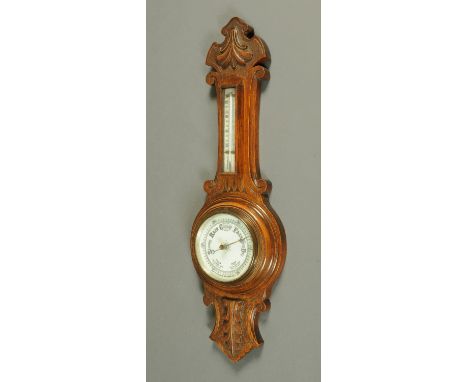 An Art Deco oak aneroid barometer, with thermometer.  Height 61 cm. 