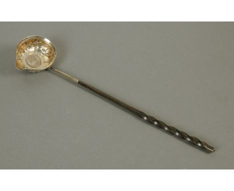 A George III ladle, with embossed silver metal bowl decorated with fruiting vines and with vacant cartouche, inset to the cen