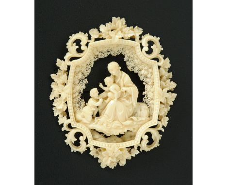 A Dieppe carved ivory brooch, depicting Mary, The Infant Child and John the Baptist framed by a floral border.  7.5 cm x 6 cm