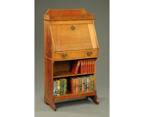 An Arts & Crafts oak students bureau, with shelf, fall front and open shelves beneath.  Width 69 cm. 