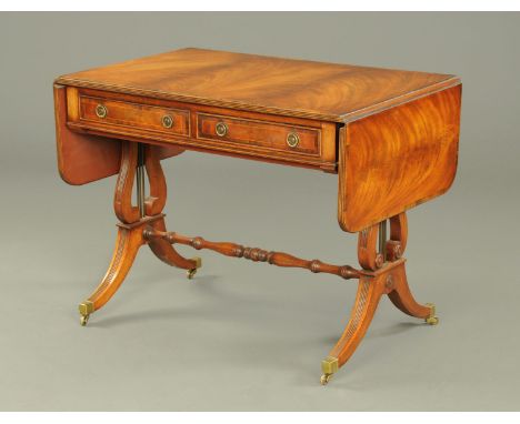 A mahogany sofa table, in the Regency style, with rosewood banded edge and fitted with two frieze drawers and with lyre shape