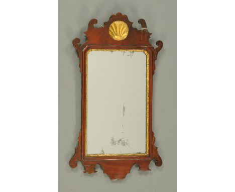 A Georgian mahogany Chippendale style fretwork mirror, with gilt slip and shell to the pediment.  Height 66 cm, width 39 cm. 
