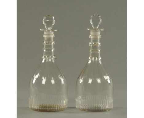 A pair of Georgian decanters, mallet form, with shaped stoppers and clear bands above four ring necks and with part faceted a