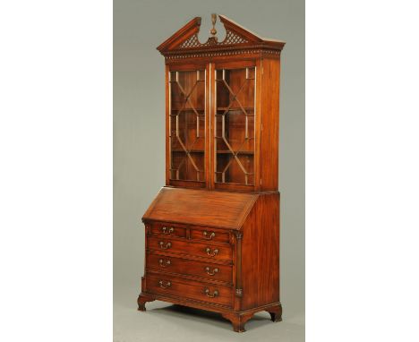 A reproduction mahogany bureau bookcase, in the Chippendale style, with broken triangular pediment above a pair of glazed doo