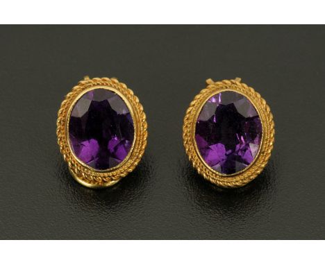 A pair of 9 ct gold mounted clip on earrings, set with amethyst coloured glass. 