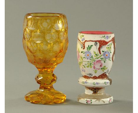 A Bohemian amber flash goblet, 19th century, the bowl with honeycomb facet and engraved with landscapes, flowers and building