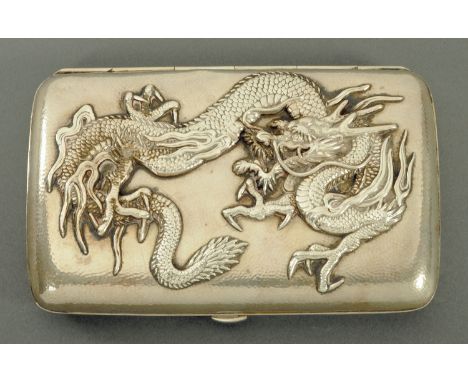 A Chinese silver cigar case, late 19th century, the lid with relief applied dragon against a planished curved rectangular bod
