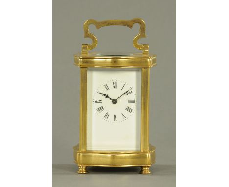 An Edwardian brass carriage clock, with serpentine case, timepiece only.  Height excluding carrying handle 12 cm. 