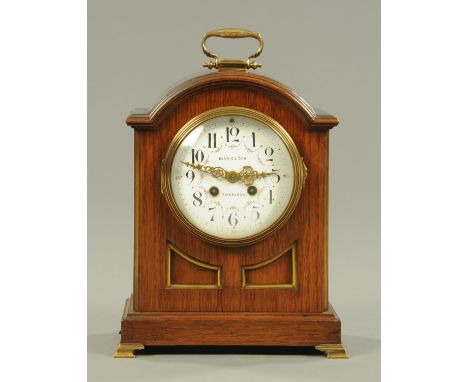 An Edwardian mahogany mantle clock, circa 1900, the enamelled dial with Arabic numerals decorated with floral garlands, with 