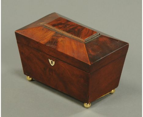A Regency mahogany tea caddy, sarcophagus form, raised on brass ball feet.  Width 22.5 cm.