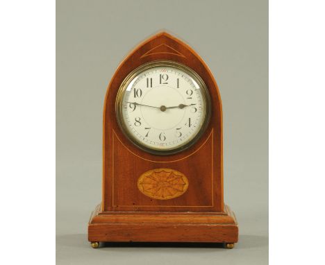 A mahogany mitre top clock, circa 1900, with enamel dial with Roman numerals, with inlaid case raised on four ball feet.  Hei