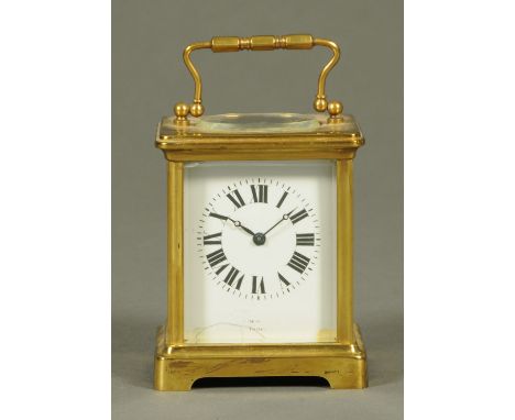 An Edwardian brass carriage clock, with Roman numerals, also inscribed "Made in France".  Height excluding carrying handle 10