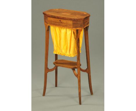 A Regency rosewood inlaid sewing table, the lift up top with canted angles, raised on splayed legs with low shelf and cloth b