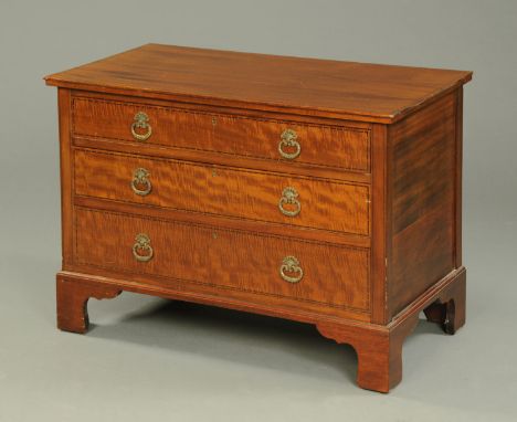 An Edwardian inlaid mahogany low chest of three drawers, with brass drop handles and raised on bracket feet.  Width 91 cm. 