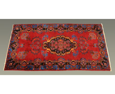 An Iranian carpet, 295 cm x 153 cm, principal colours red, blue and green.