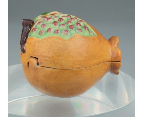 Age:   Description: A Chinese polychrome ceramic erotic box of pomegranate form, naturally modeled, opening to reveal a coupl