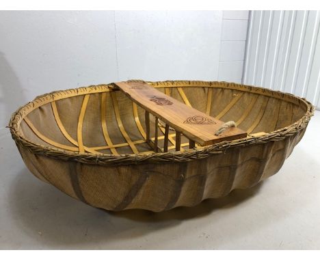 Coracle boat made by Flaxland using wood, woven flax and natural resins, the seat carved with Irish Celtic designs, not teste