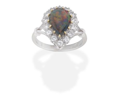 BLACK OPAL AND DIAMOND RINGThe pear-shaped black opal cabochon, within a brilliant-cut diamond surround, ring size approx. K½