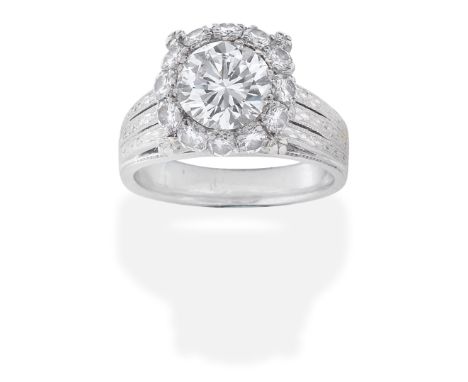 DIAMOND RINGThe old brilliant-cut diamond, weighing 1.69 carats, within a brilliant-cut diamond surround, the shoulders and h