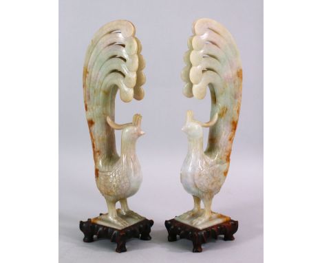 A PAIR OF CHINESE CARVED JADE FIGURES OF PEACOCKS, both with their tails aloft, on hardwood naturalistic carved bases, 19cm h