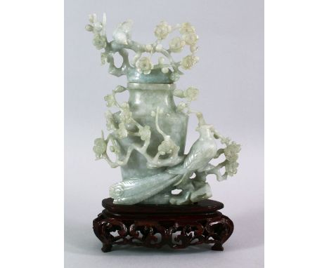 A CHINESE CARVED JADE FLORAL URN &amp; COVER, carved with a display of flora and birds, upon a carved wooden stand, 19cm high