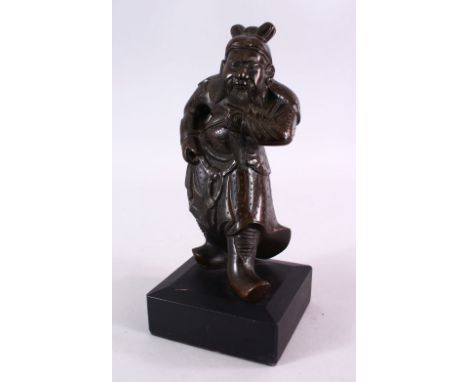 A 19TH CENTURY CHINESE BRONZE FIGURE OF GUANDI - in a striding pose with a wooden base, 22cm x 12cm