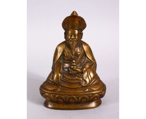 A CHINESE BRONZE FIGURE OF BUDDHA,L in a seated position holding an implement, 13cm.