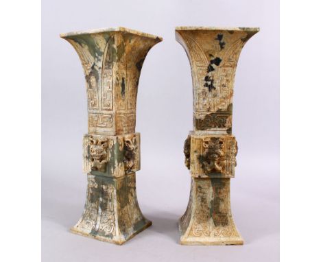 A PAIR OF 19TH / 20TH CENTURY CHINESE ARCHAIC STYLE CARVED JADE VASES, each vase with a central section carved in relief depi