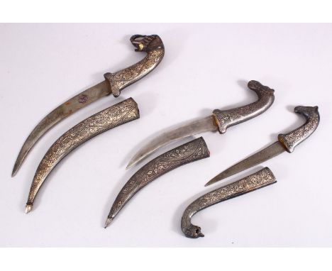 A LOT OF THREE 19TH CENTURY SILVER INLAID NIELLO DAGGERS, One with an elephant head handle, with a watered steel blade and st