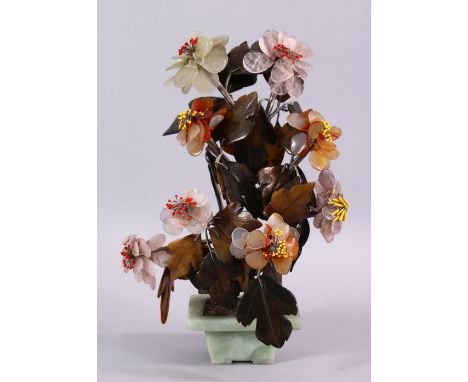 A CHINESE CARVED JADE MODEL OF A TREE, in a small pot with an elaborate spray of flora, 26cm high x 17cm wide.