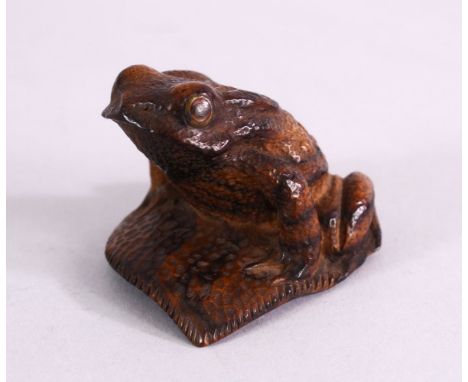 A JAPANESE 19TH / 20TH CENTURY CARVED WOOD SEATED FROG UPON LEAF - the frog in a seated position upon a leaf, with brass inla