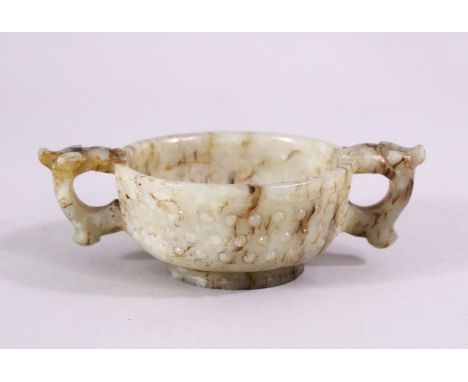 A CHINESE CARVED JADE ARCHAIC STYLE TWIN HANDLE CUP, with chilong handles, and boss decoration, 11cm diameter.