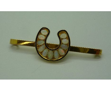 A 9ct gold and opal horseshoe brooch, weight 4.8g, one stone a/f