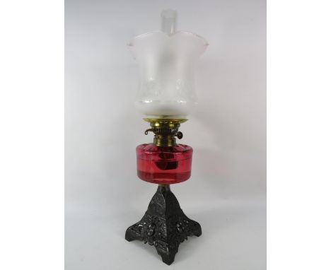 Antique oil lamp with cranberry glass reserve, cast iron base &amp; etched glass shade. 22.5" to top of chimney.