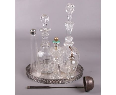 An antique silver toddy ladle along with a collection of glass. Including silver topped atomisers, decanters, etc.  