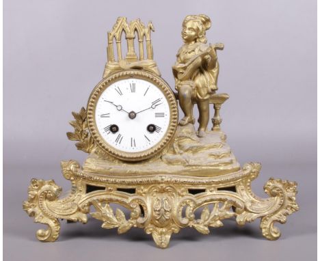 A late 19th/early 20th Century gilt metal mantel clock, depicting a gentleman with a lute. Chiming on a bell.  Glass missing 