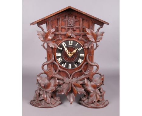 An oak cased Black Forest mantel cuckoo clock with carved acanthus leaf decoration. Height 49.5cm  Running.