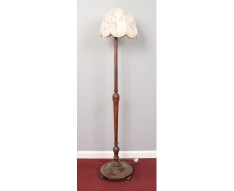 An oak turned standard lamp with circular base and shade. H: 150cm.  