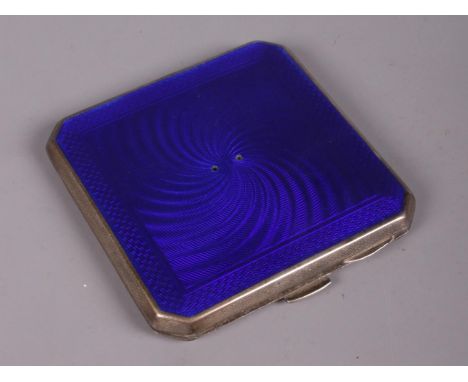 A Silver compact with guilloche blue enamel design. Assayed in Birmingham 1913. Markers mark unclear. H: 7cm W: 7cm.  Missing