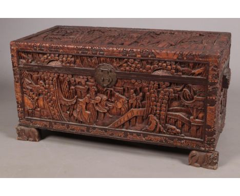 An extensively carved Chinese hardwood trunk with camphor wood lining. The feet formed as dog of fo.  