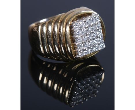 A yellow metal and diamond ring. The stepped shoulders supporting a square panel of twenty five brilliant cut diamonds. Each 