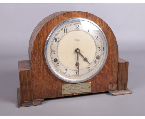 An domed Oak cased mantle clock by G.H Gill with Garrard movement. Has a plaque inscribed with 'presented to Commander Bowlby